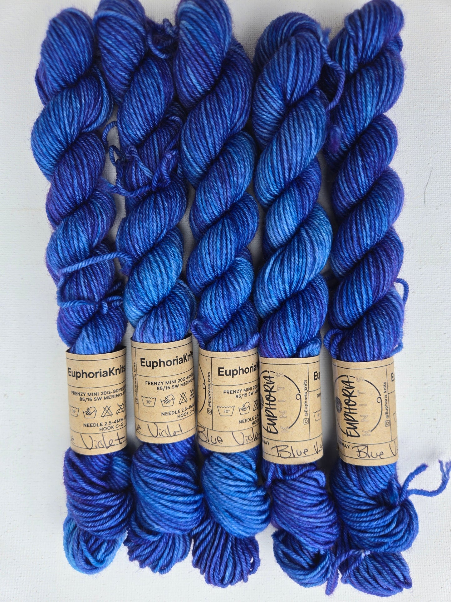 Blue yarn skeins with labels on a white background