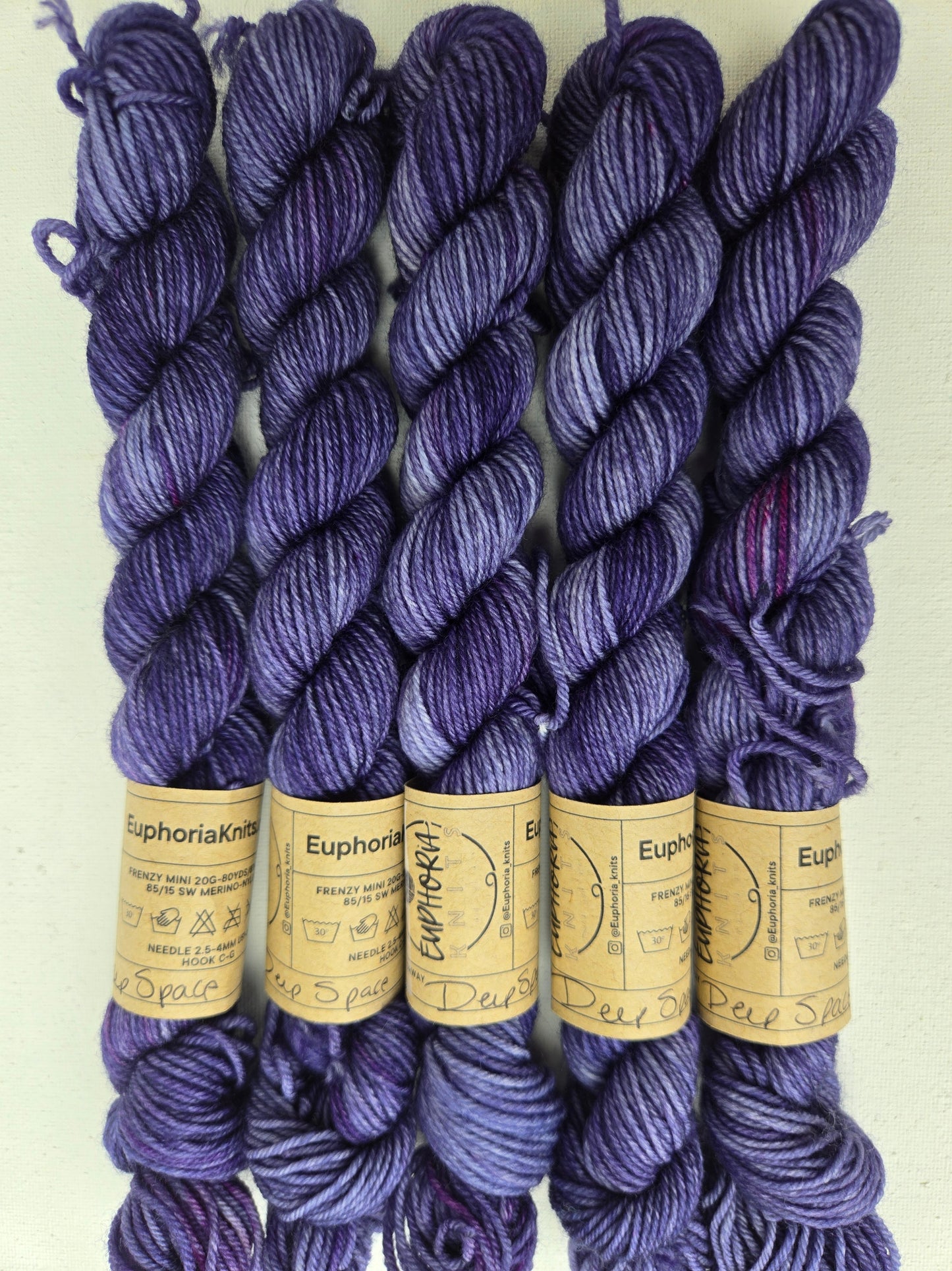 Purple yarn skeins with visible labels on a light background