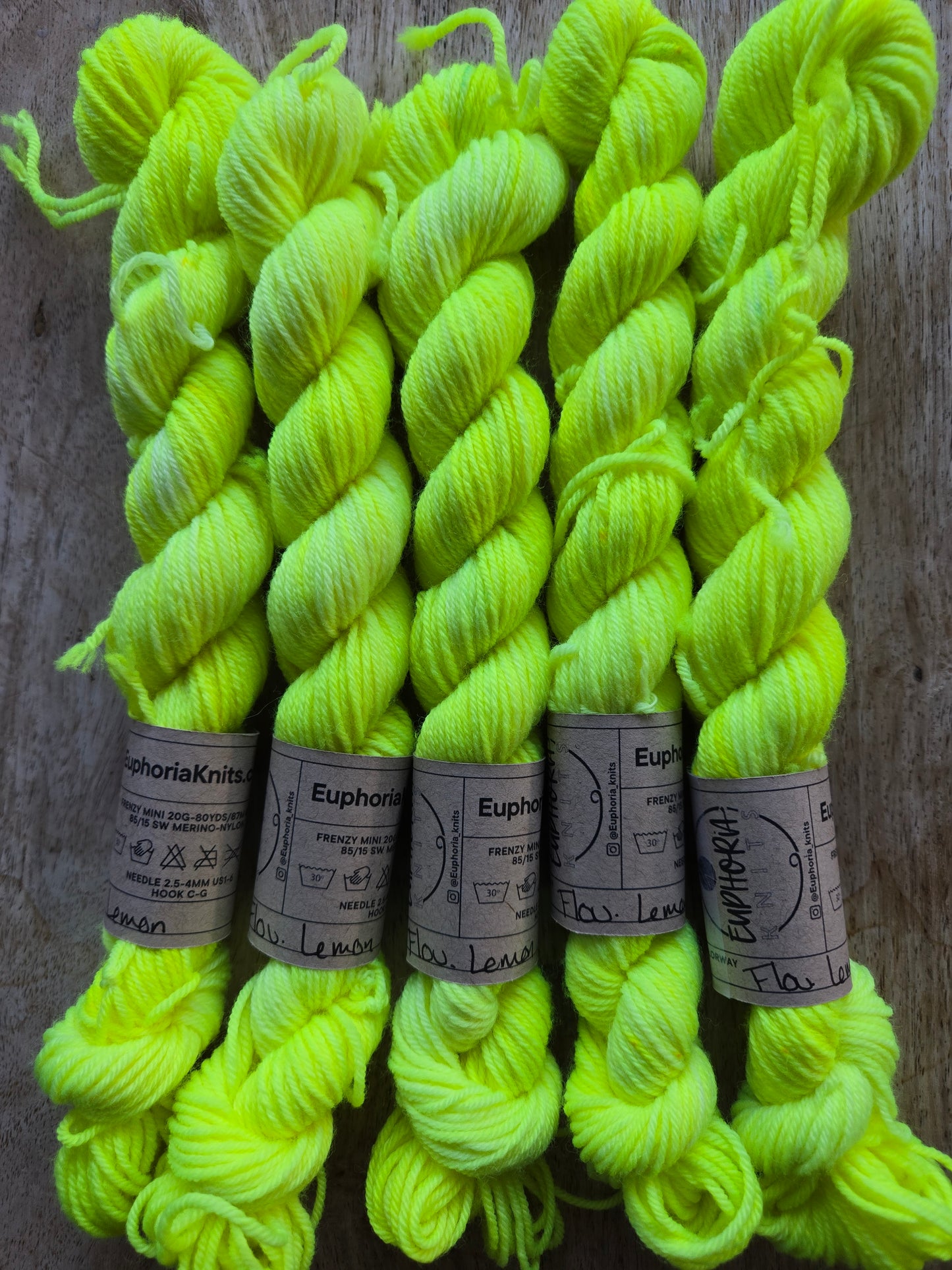 Neon green yarn skeins with labels on a wooden surface