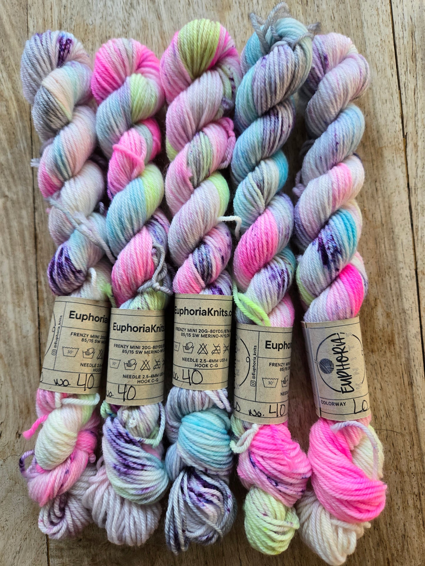 Colorful yarn skeins with labels on a wooden surface