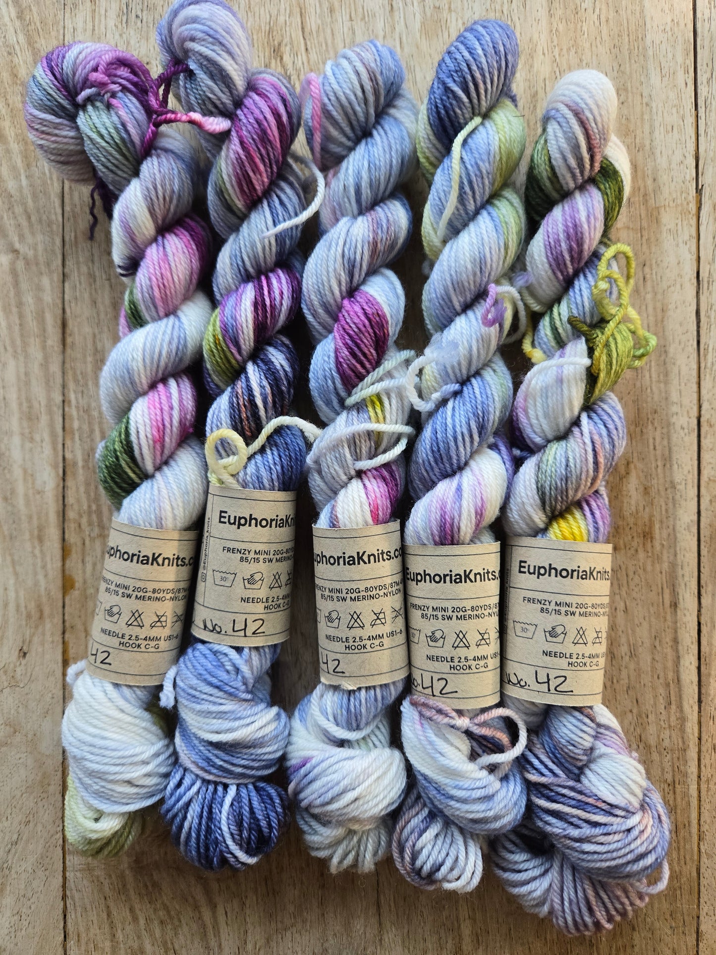 Multicolored yarn skeins with labels on a wooden surface