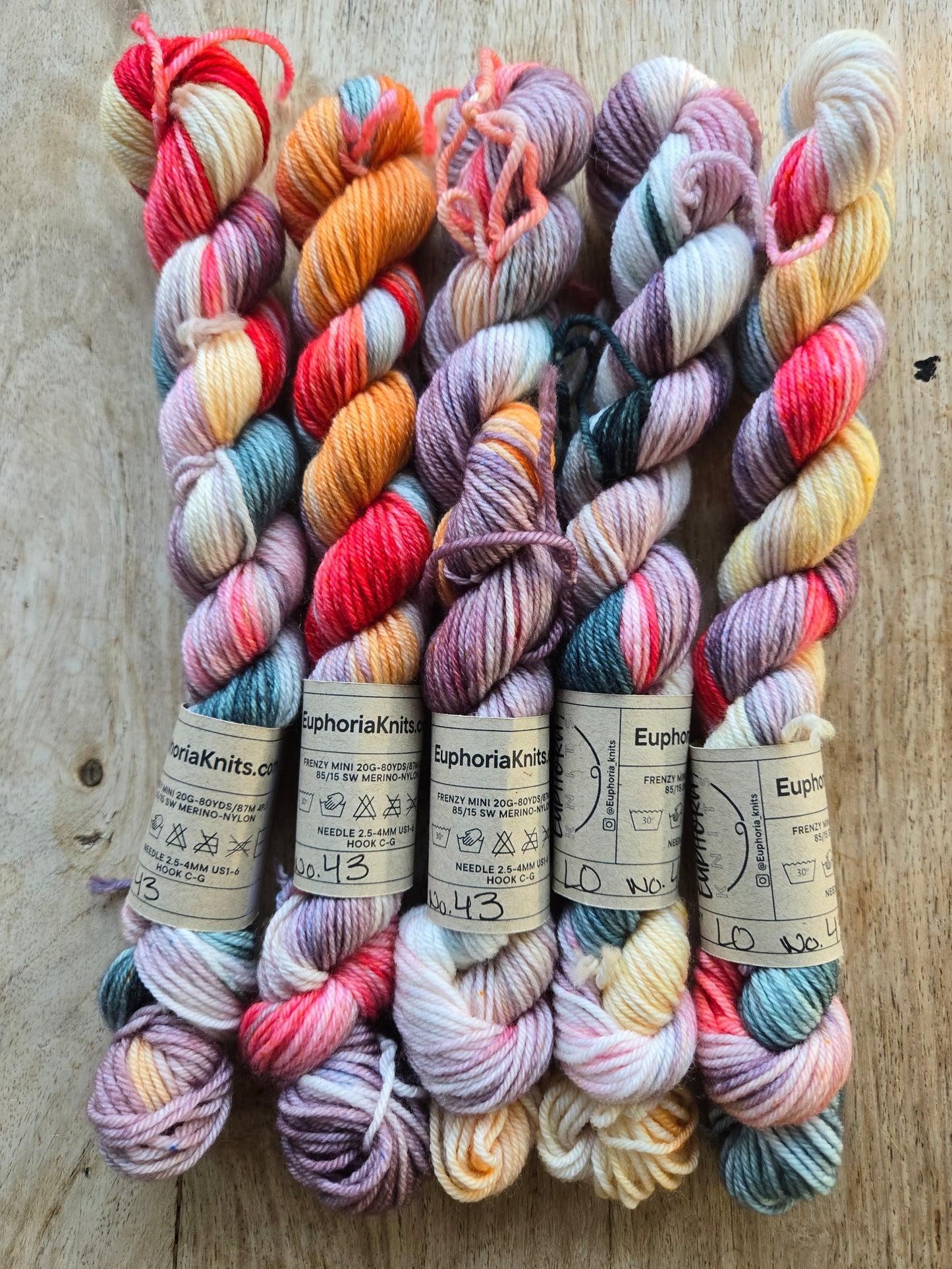 Colorful yarn skeins with labels on a wooden surface