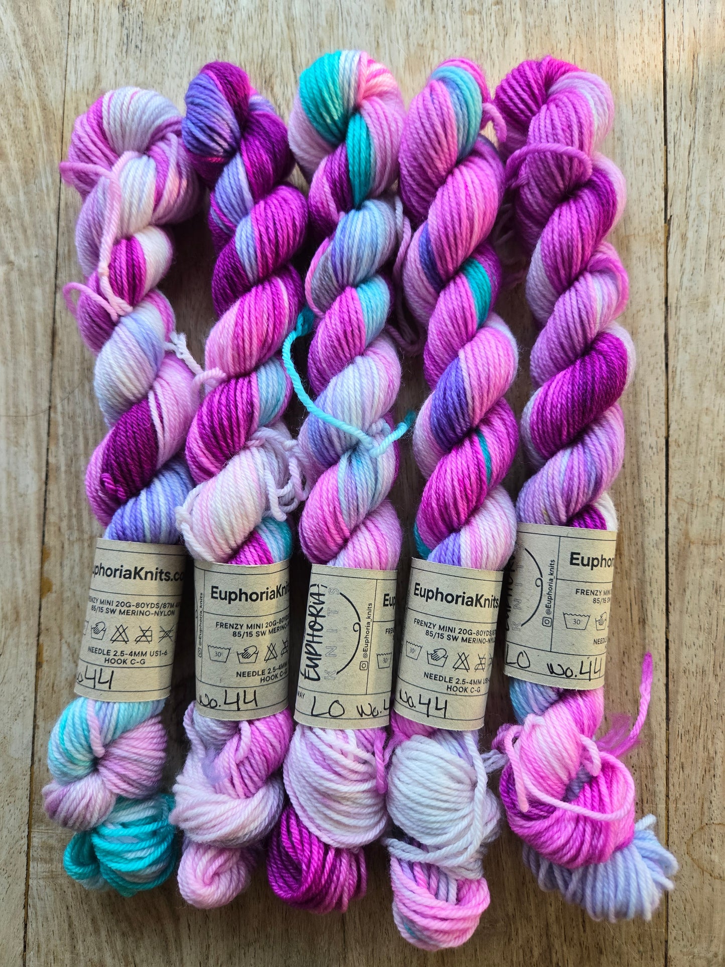 Colorful yarn skeins with labels on a wooden surface