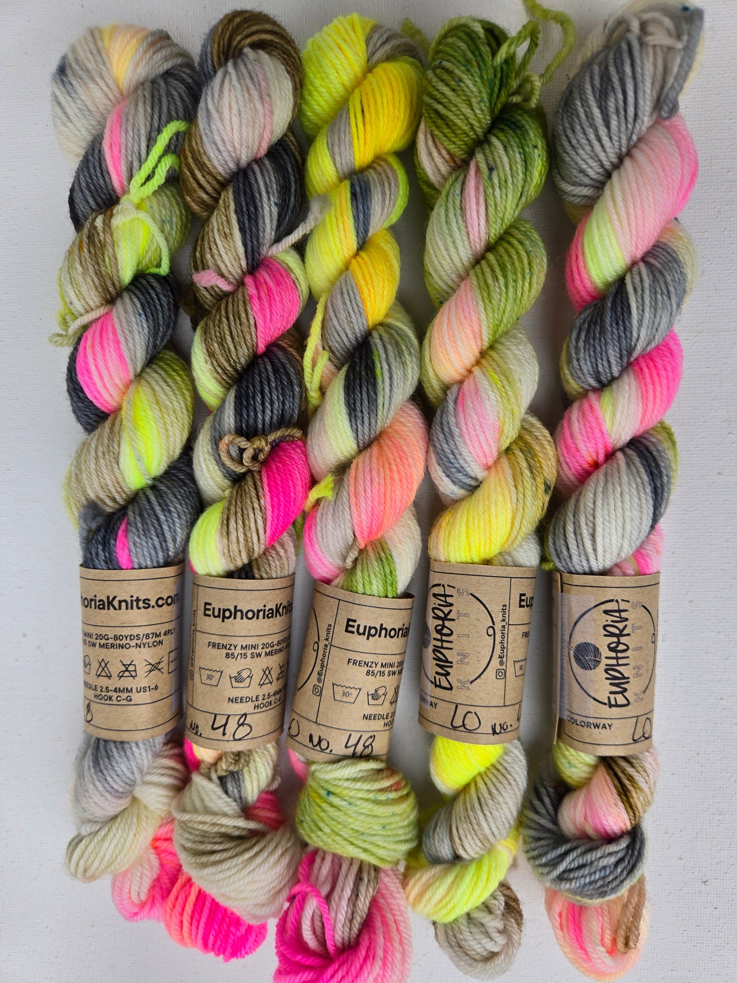 Colorful yarn skeins with visible brand labels on a white background