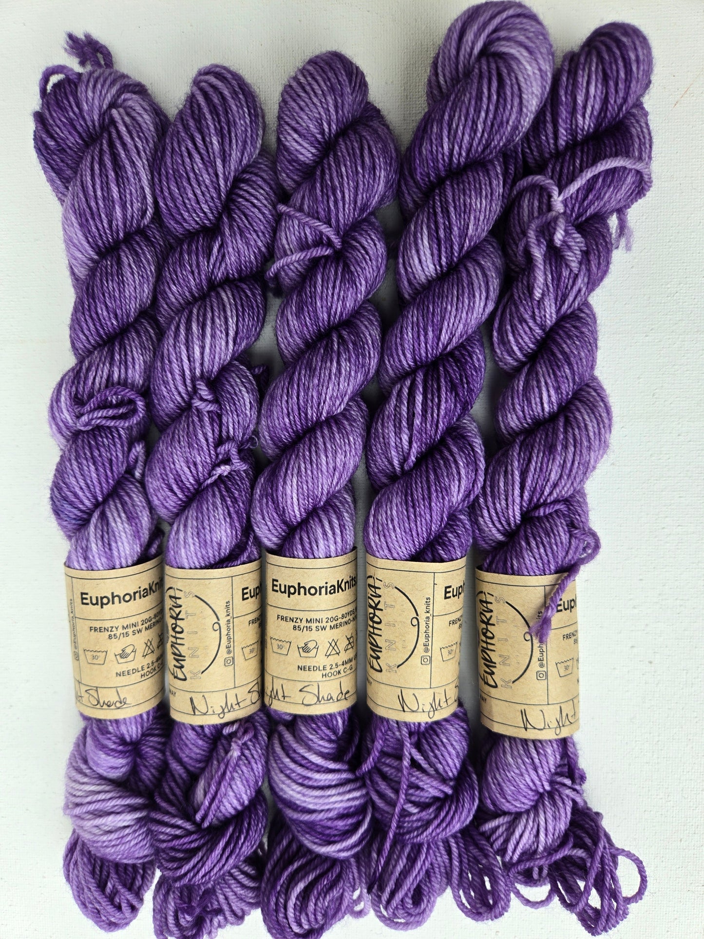 Purple yarn skeins with labels on a white background