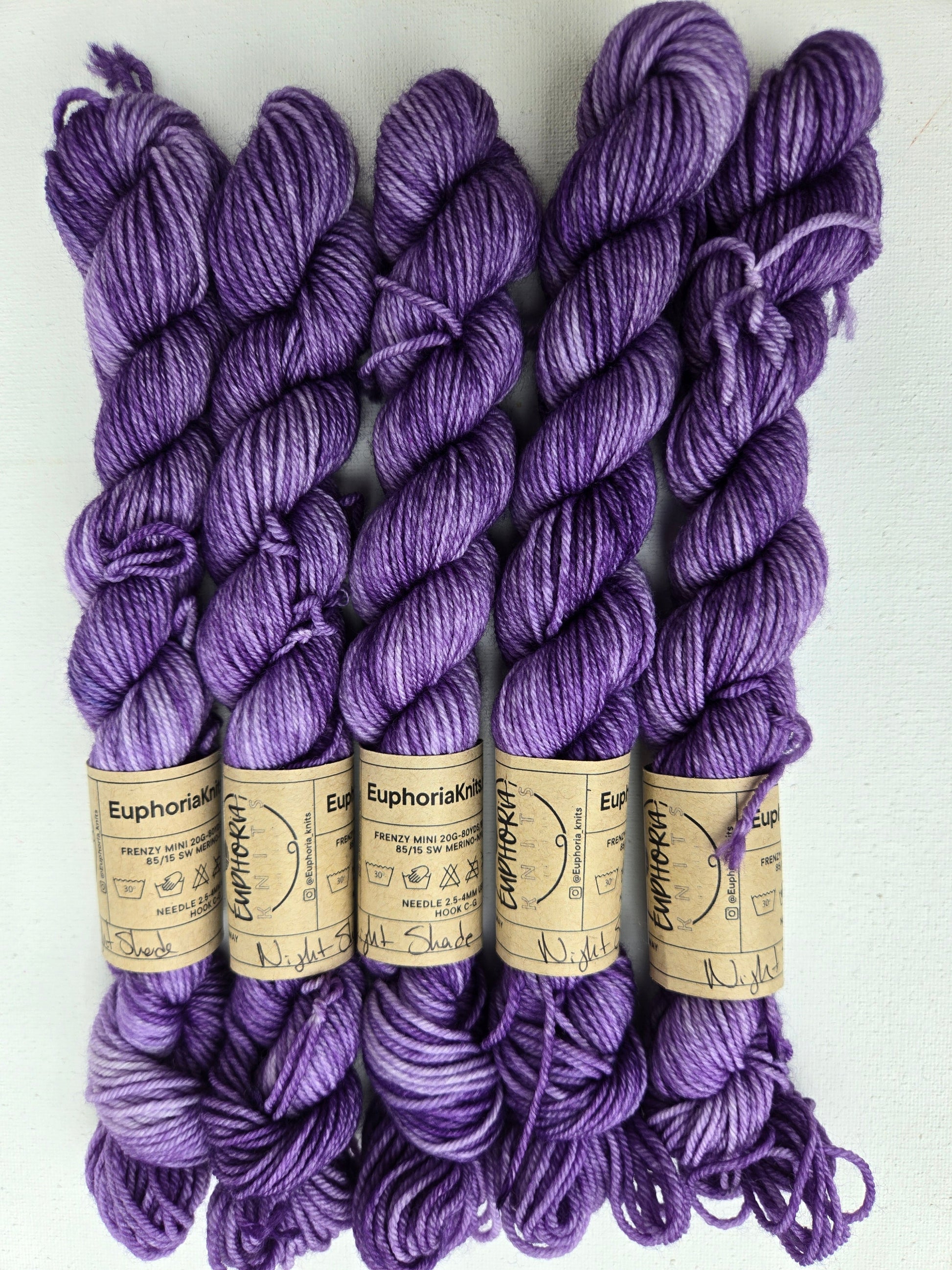 Purple yarn skeins with labels on a white background