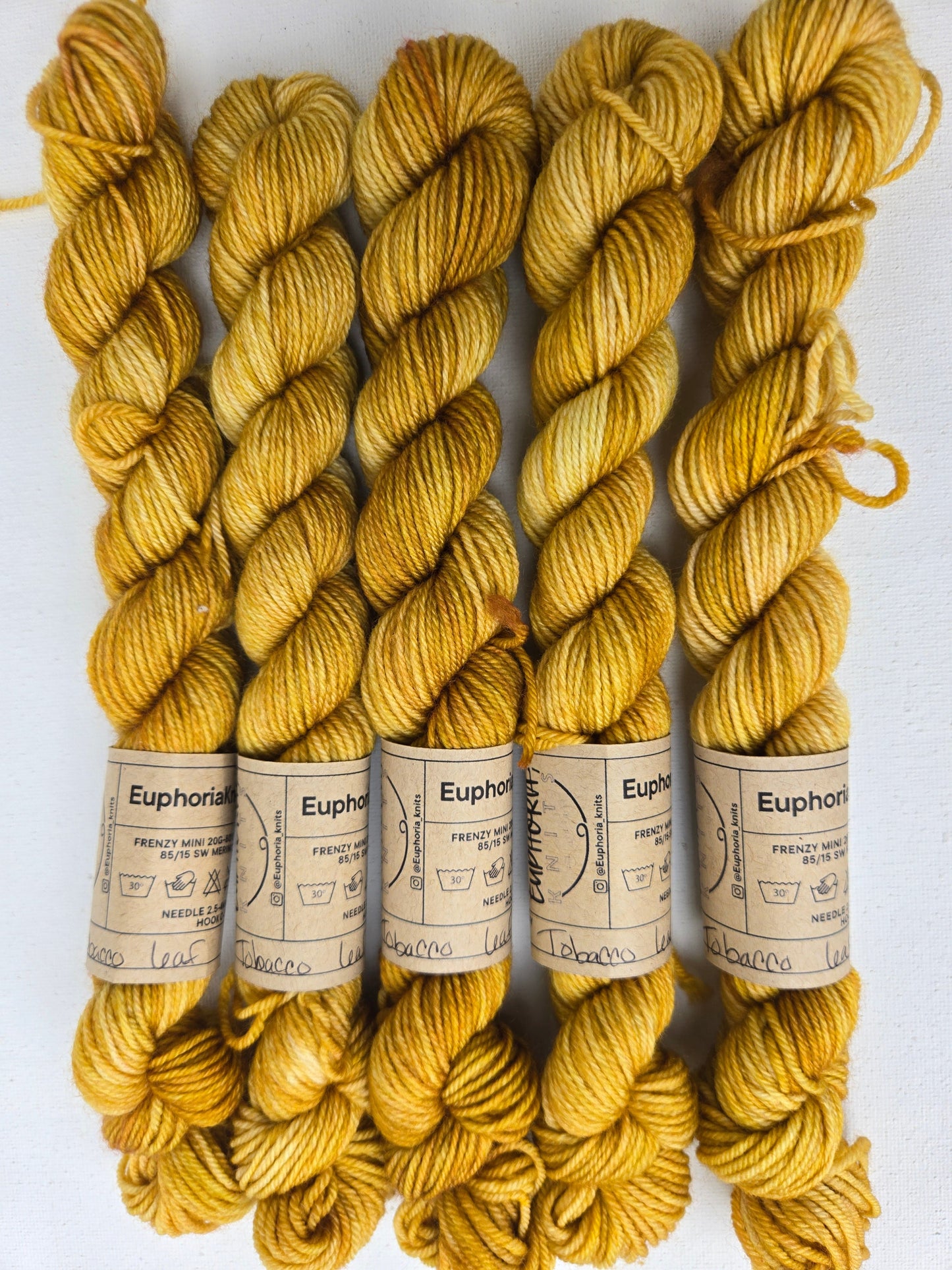 Yellow yarn skeins with labels on a white background
