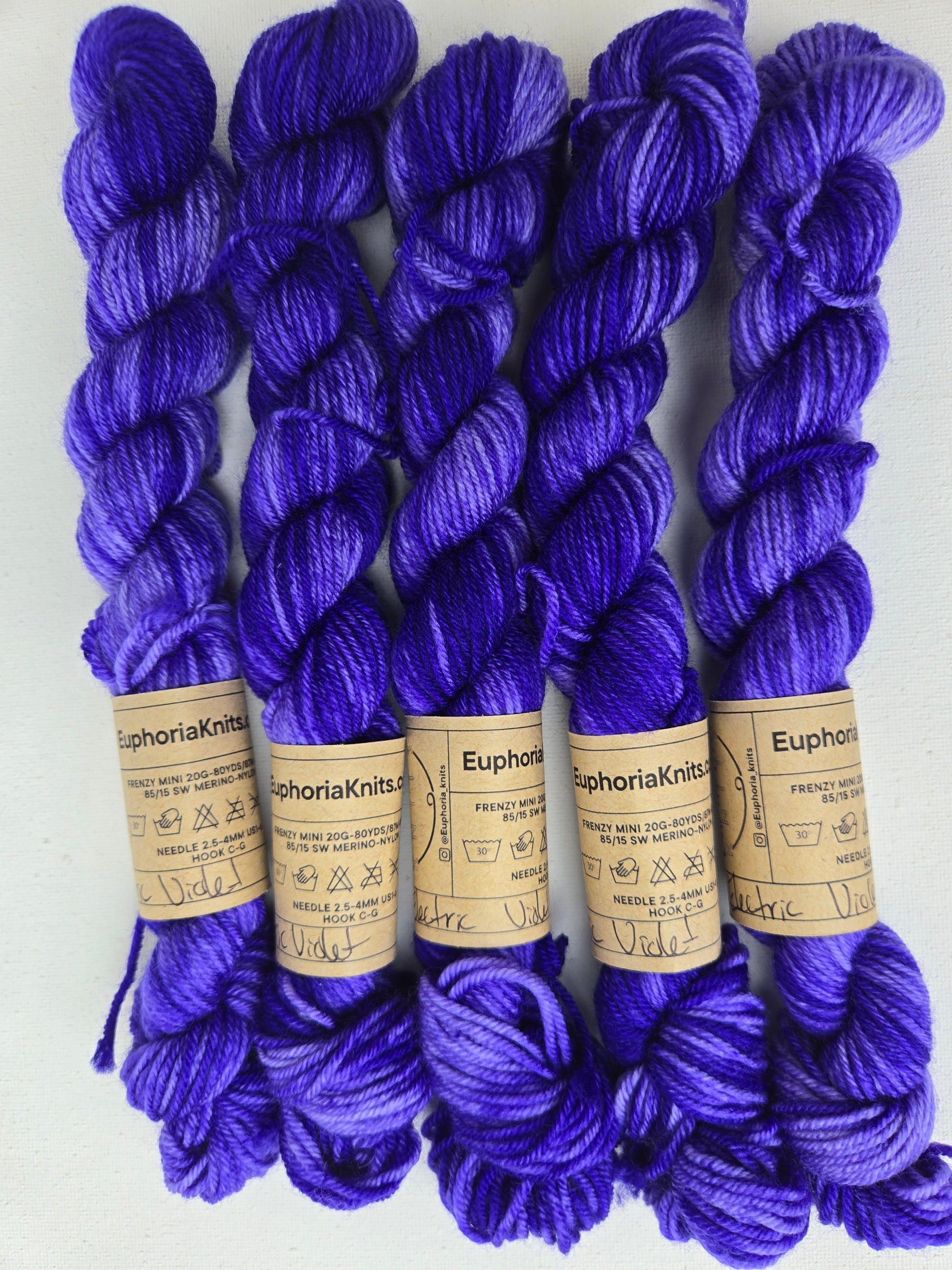 Purple yarn skeins with labels on a white background