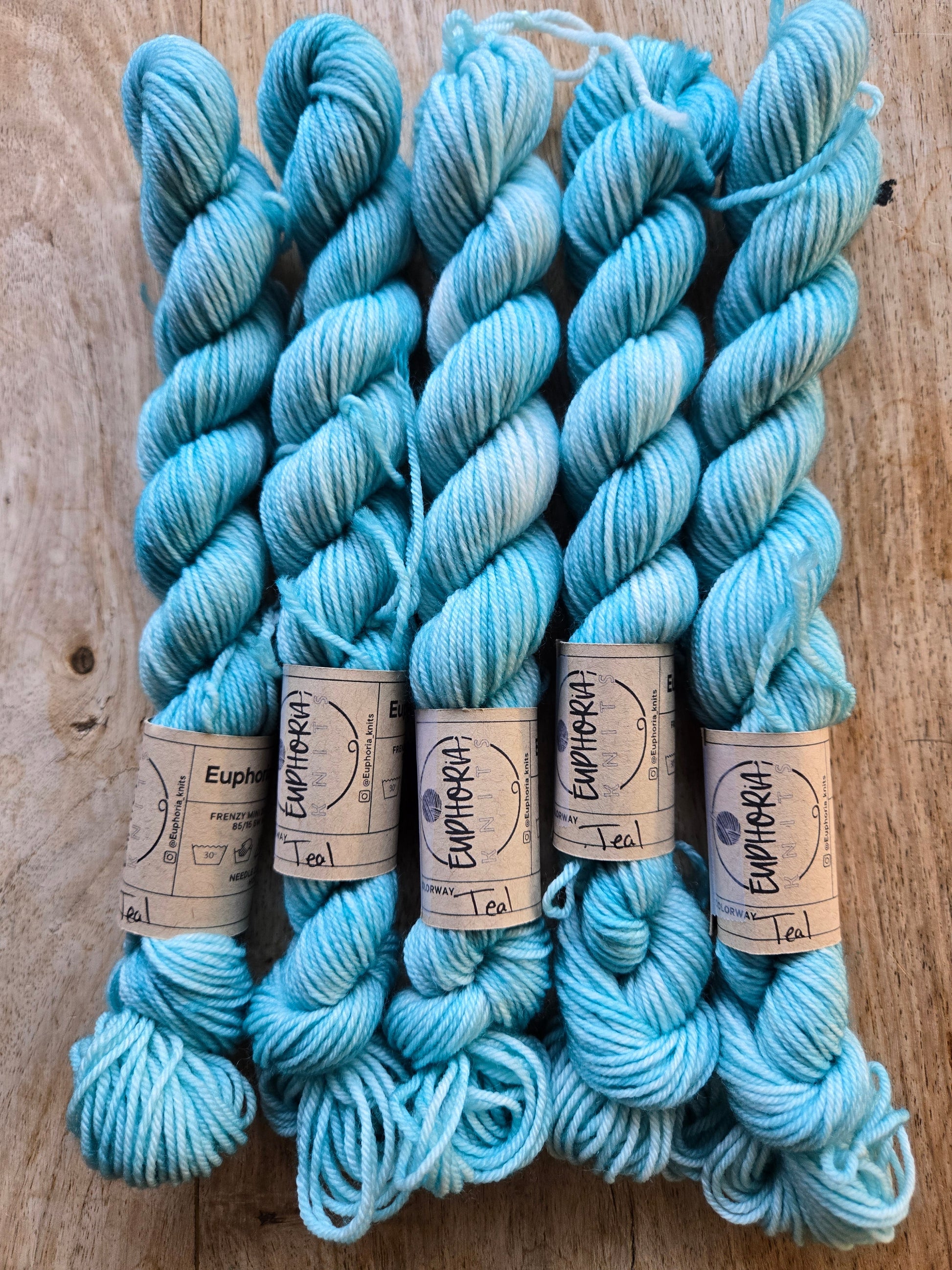 Blue yarn skeins with labels on a wooden surface
